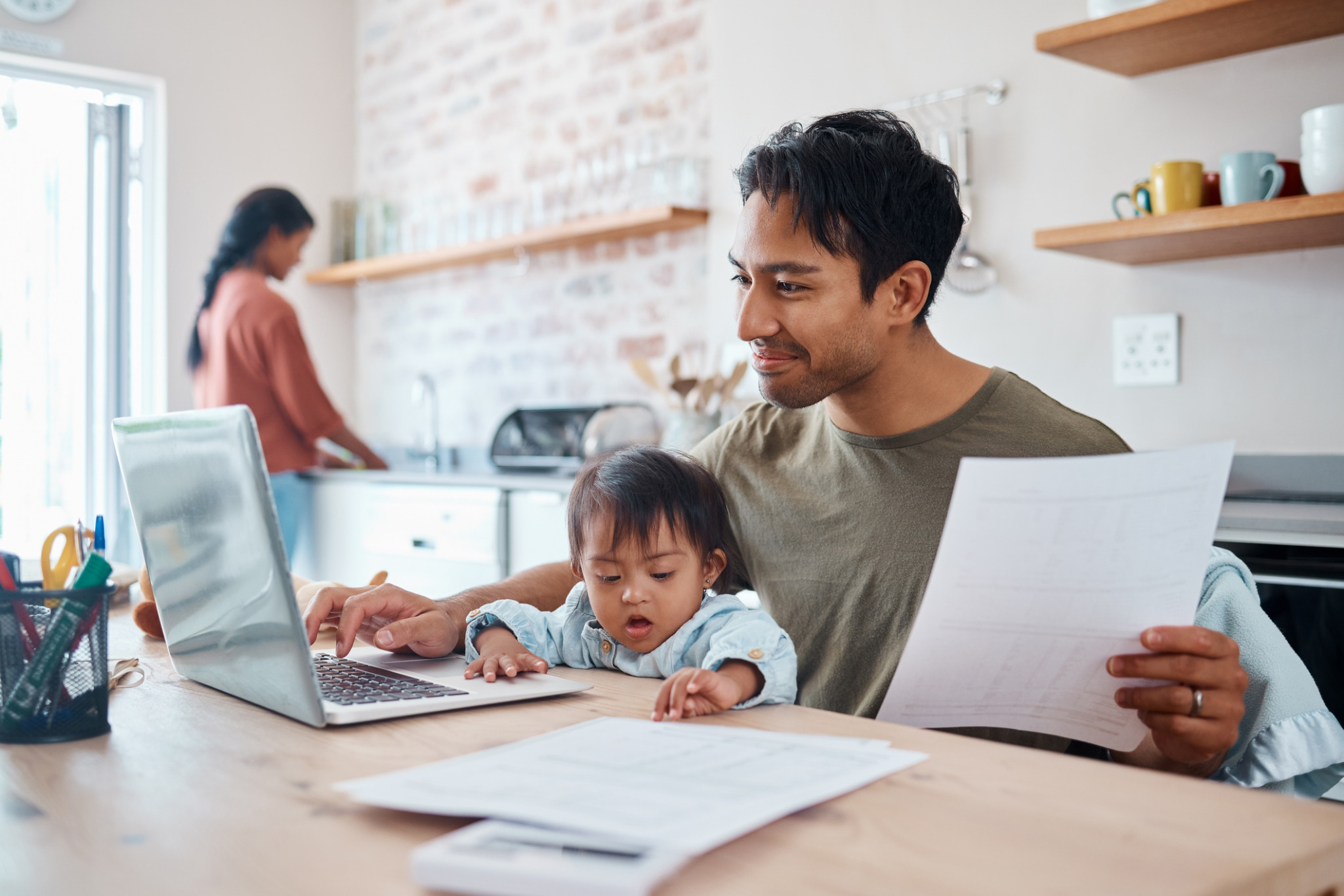 Family in the kitchen working on a laptop